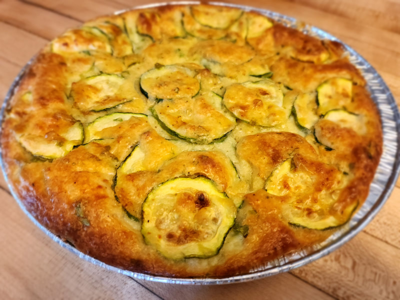 Torte di Zucchini
A savory pie with thinly sliced zucchini, eggs, parmasean cheese, fresh parsley and diced onions in a golden delicious batter.